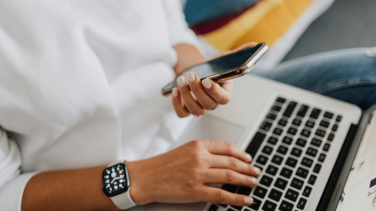Notebook e celular representando notificação eletônica.