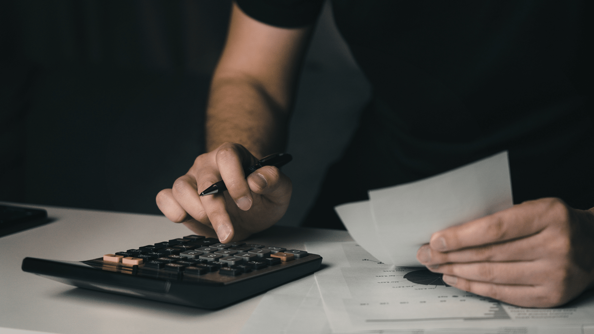 Imagem de mão calculando. Representa arbitragem na inadimplência condominial.